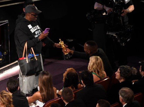 Mahershala Ali, right, hands his award for best actor in a supporting role for "Moonlight" to a tourist named Gary during the Oscars on Sunday, Feb. 26, 2017, at the Dolby Theatre in Los Angeles. (Photo by Chris Pizzello/Invision/AP)
