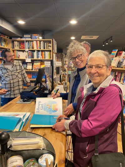 Karen and Nancy sharing a look and a signature on LIBRARY GIRL.